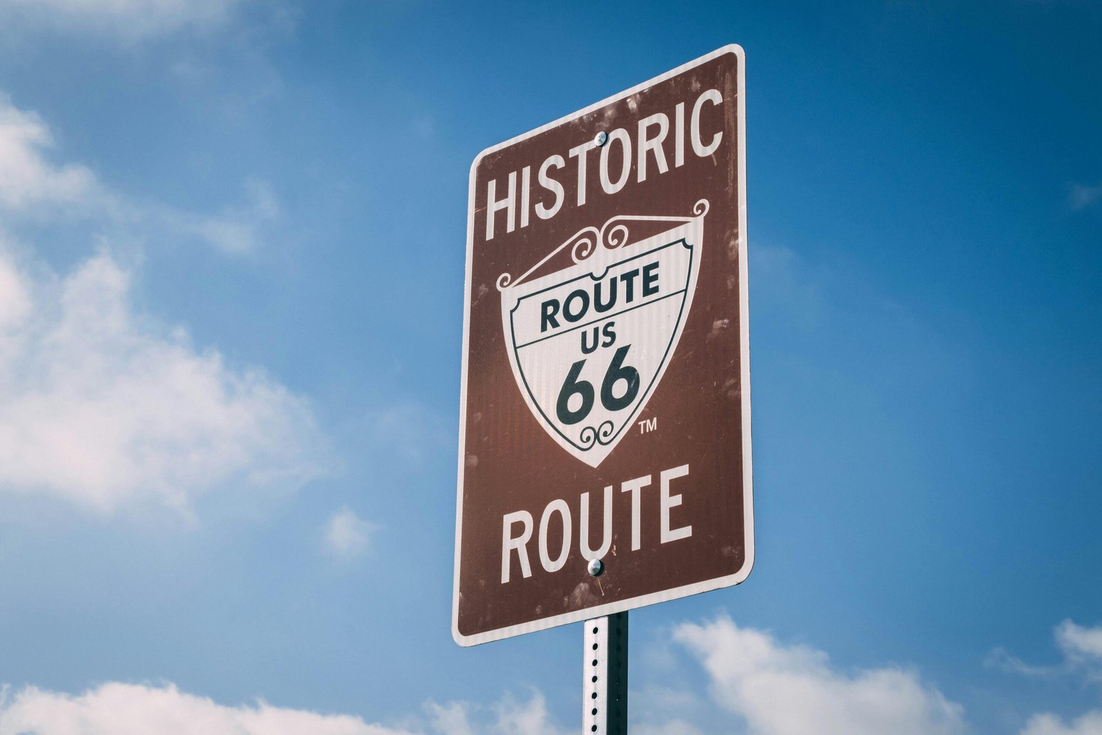 A classic Route 66 sign on a clear day, representing American road trip culture.